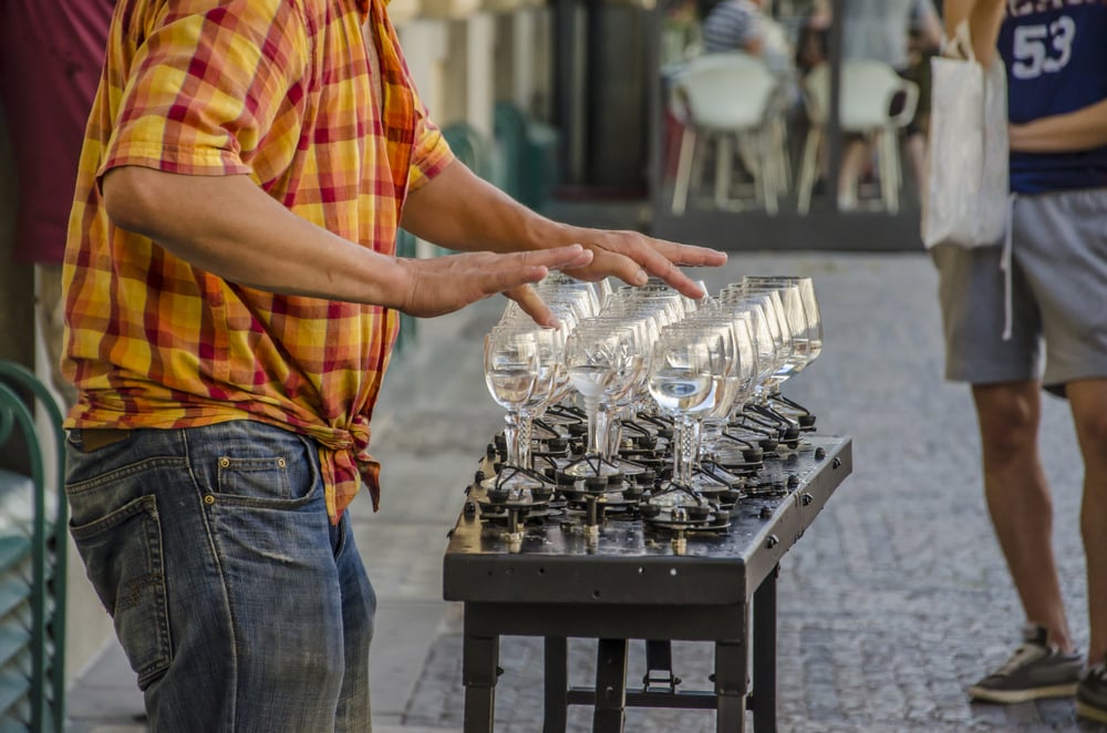 Man-playing-music-on-the-rims-of-wine-glasses