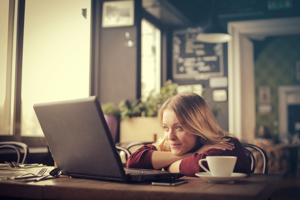 Young-woman-watching-a-video-on-her-computer-at-a-coffee-shop