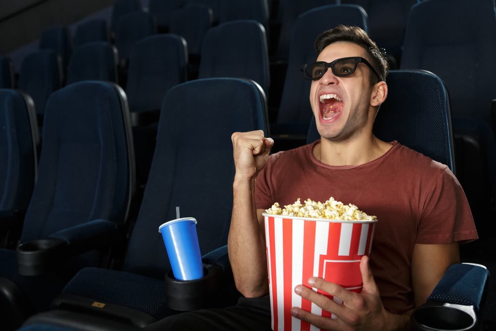 Young-man-watching-movie-at-movie-theater-wearing-3D-glasses