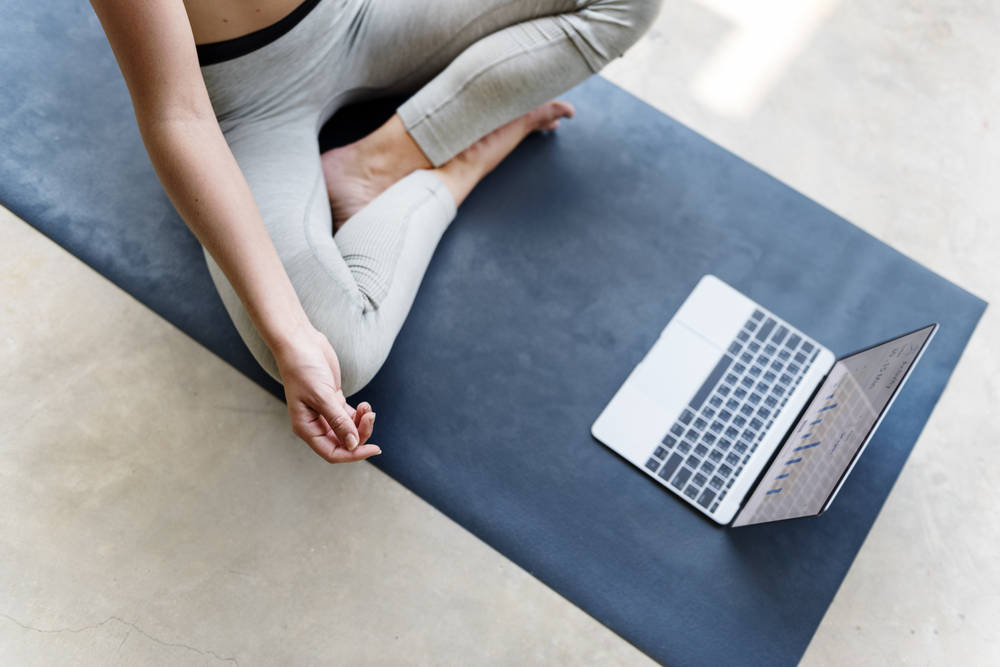 Woman watches video while performing yoga.